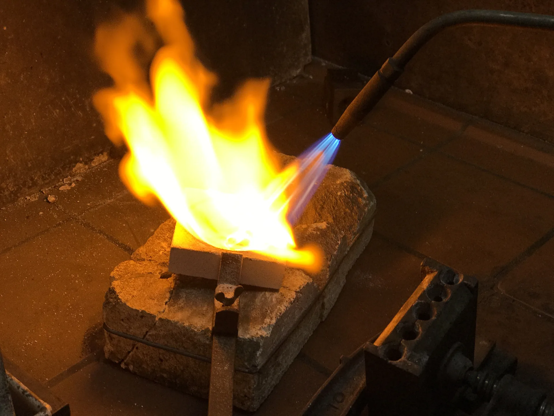 Schmelztiegel, in dem Gold mit der Flamme geschmolzen wird