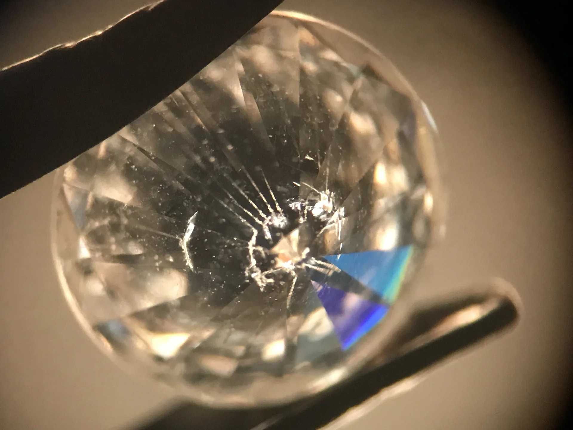 Diamant mit vier Laserbohrkanälen, durch die Unterseite betrachtet; Mehrfachspiegelungen in den Unterteilfacetten