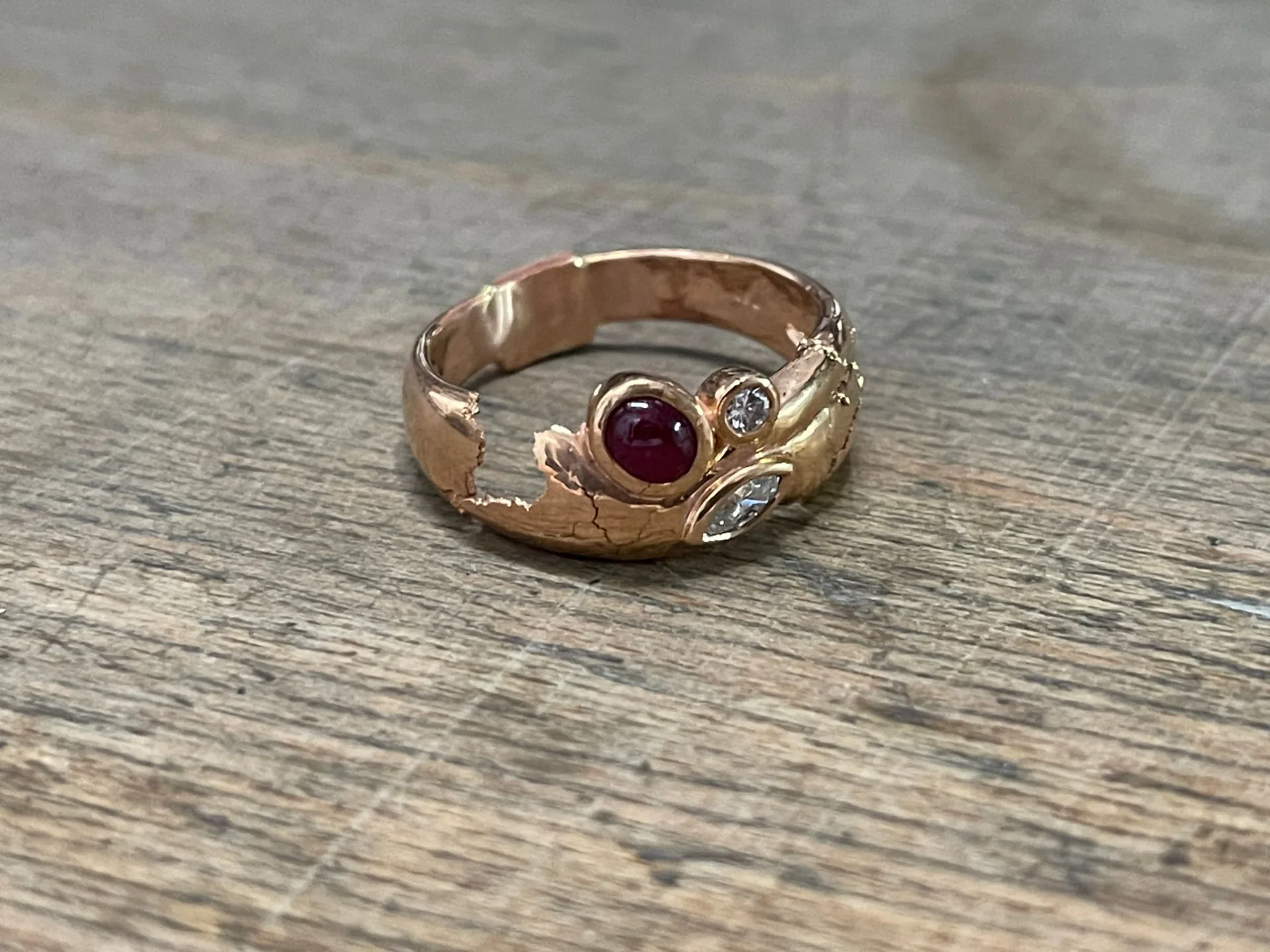 Ansicht von oben mit Rubin-Cabochon und zwei Diamanten, die Schiene ist großflächig aufgebrochen