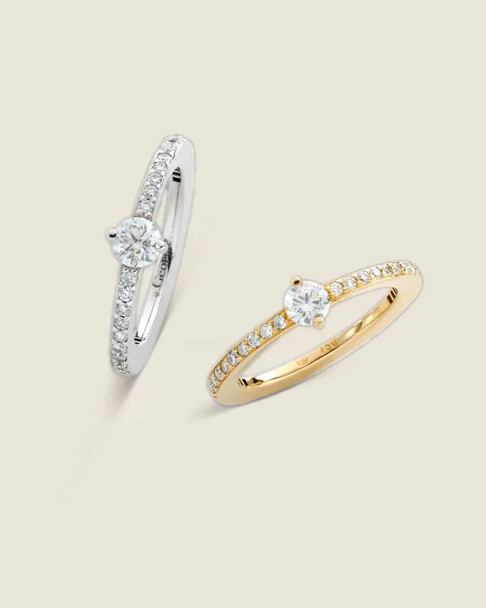 Zwei Solitärringe mit Diamanten, in Weiß- und Gelbgold, mit Diamantbesatz in der Schiene